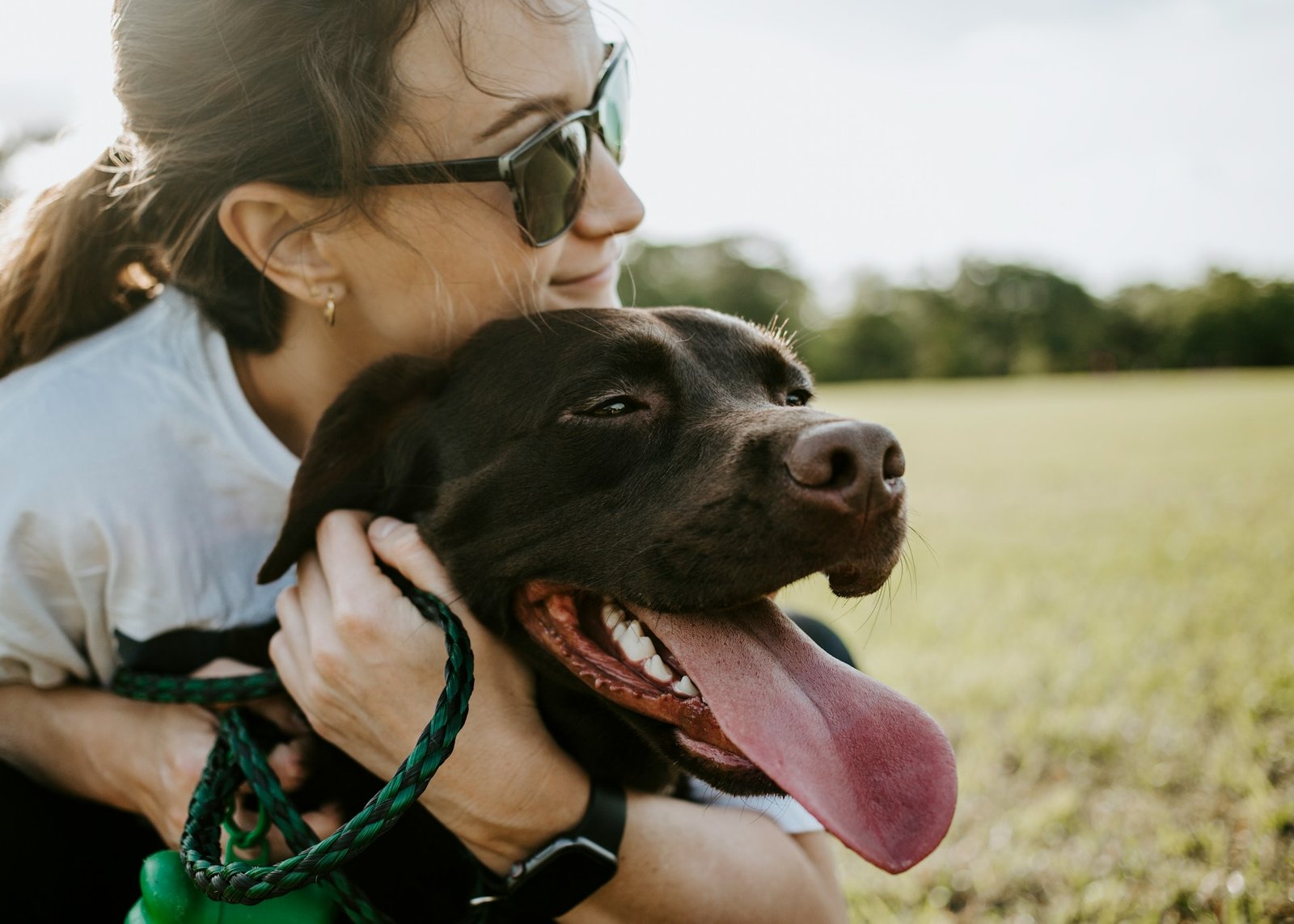 Une femme tenant son chien contre elle en extérieur